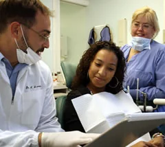 Dr. Levesque reviewing a treatment plan with a relaxed patient in the chair